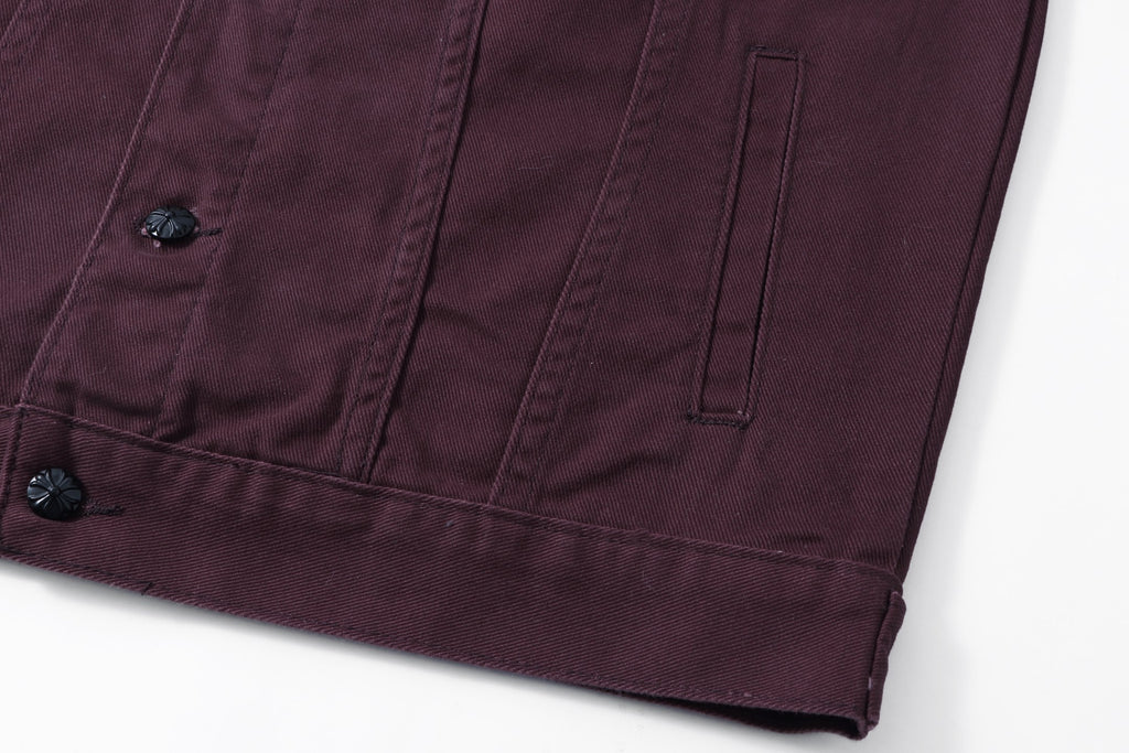 Lower front pocket seam and button detail on dark plum long-sleeve jacket