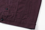 Lower front pocket seam and button detail on dark plum long-sleeve jacket