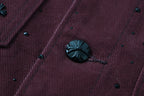 Long-sleeve jacket fabric detail with embroidered speckles and dark button