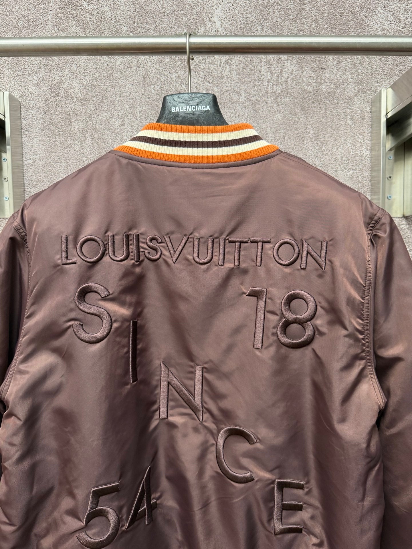 Louis Vuitton long bomber jacket, back view with LouisVuitton text and large stitched letters