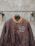 Louis Vuitton long bomber jacket, front view with LV M Since 1854 patch and striped collar