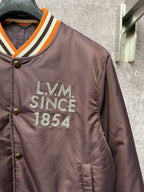 Louis Vuitton long bomber jacket close-up on chest logo reading LVM Since 1854
