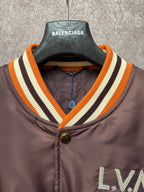Louis Vuitton long bomber jacket neckline close-up with striped rib trim and metal snap