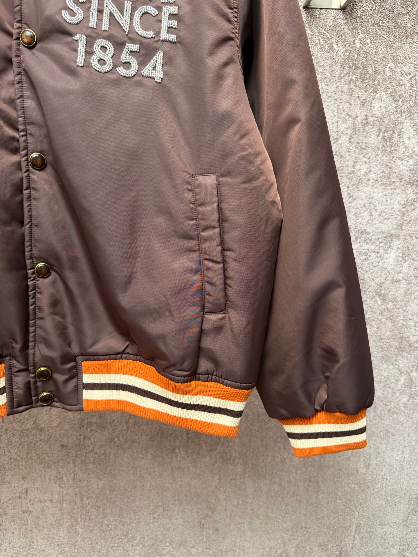 Louis Vuitton long bomber jacket, lower front view with orange-and-cream rib hem stripes