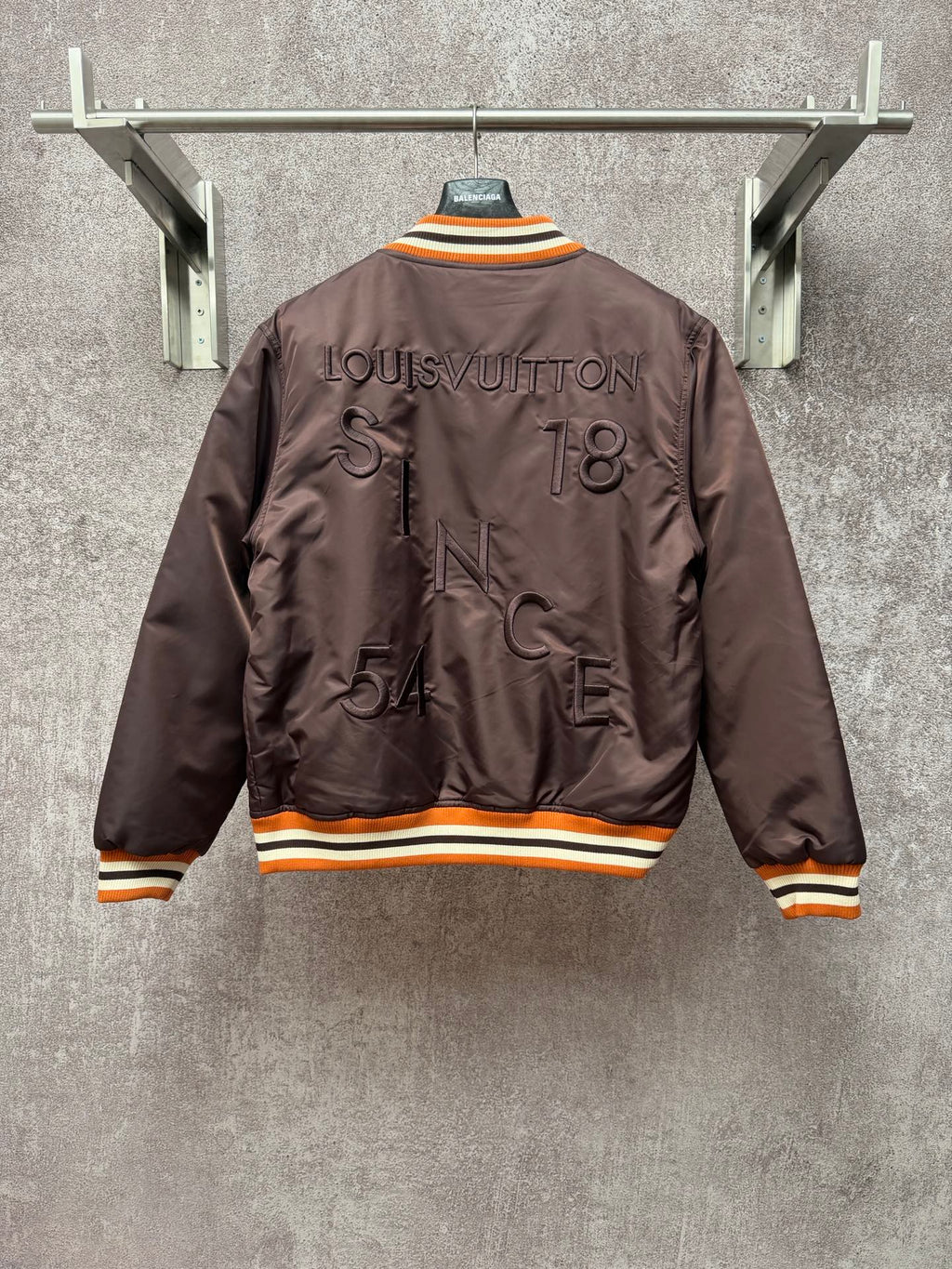 Louis Vuitton long bomber jacket, back view with raised logo and striped orange rib trim