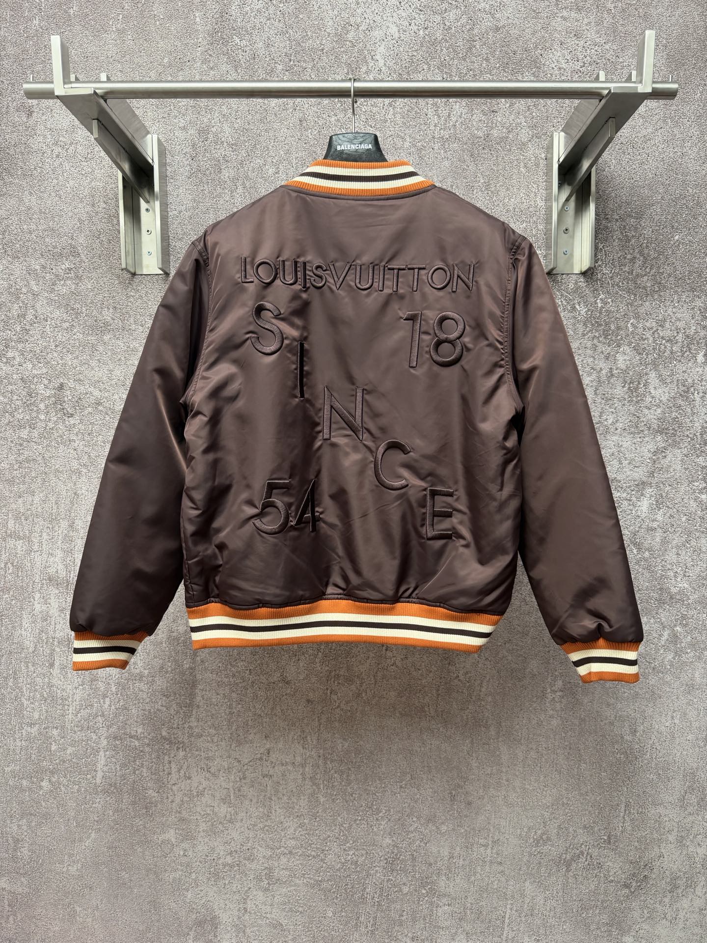 Louis Vuitton long bomber jacket, back view with raised logo and striped orange rib trim