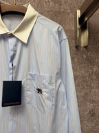 Light blue pinstripe shirt with cream spread collar and embroidered chest emblem