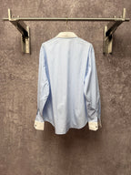 Light blue pinstripe button-up shirt, back view with cream cuffs
