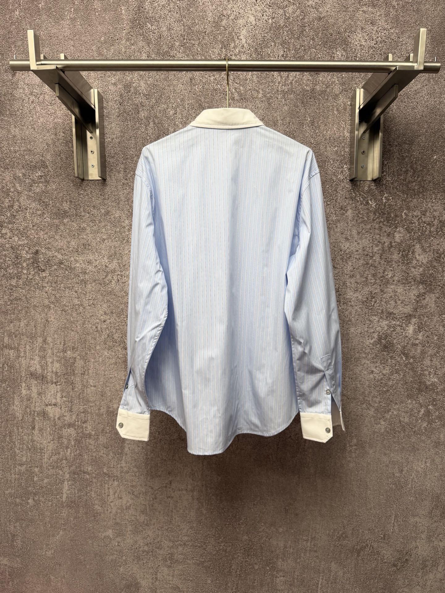 Light blue pinstripe button-up shirt, back view with cream cuffs