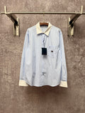 Light blue pinstripe button-up shirt with cream collar and chest pocket