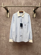 Light blue pinstripe button-up shirt with cream collar and chest pocket