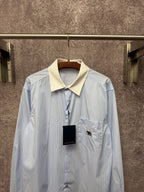 Light blue pinstripe button-up shirt with cream collar and chest pocket