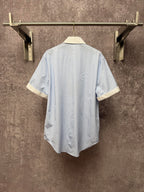 Light blue striped short-sleeve shirt with cream collar trim, back view