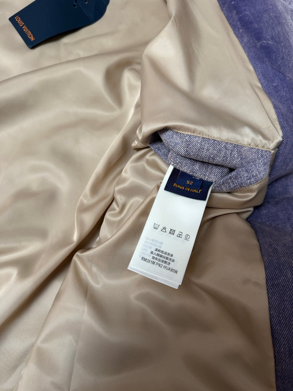 Beige long-sleeve outerwear with denim cuff and hanging size label