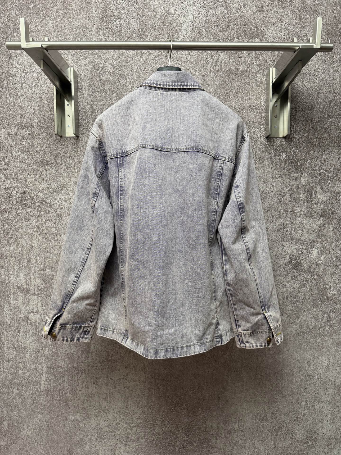 Light blue denim jacket back view with yoke seam and stitched collar