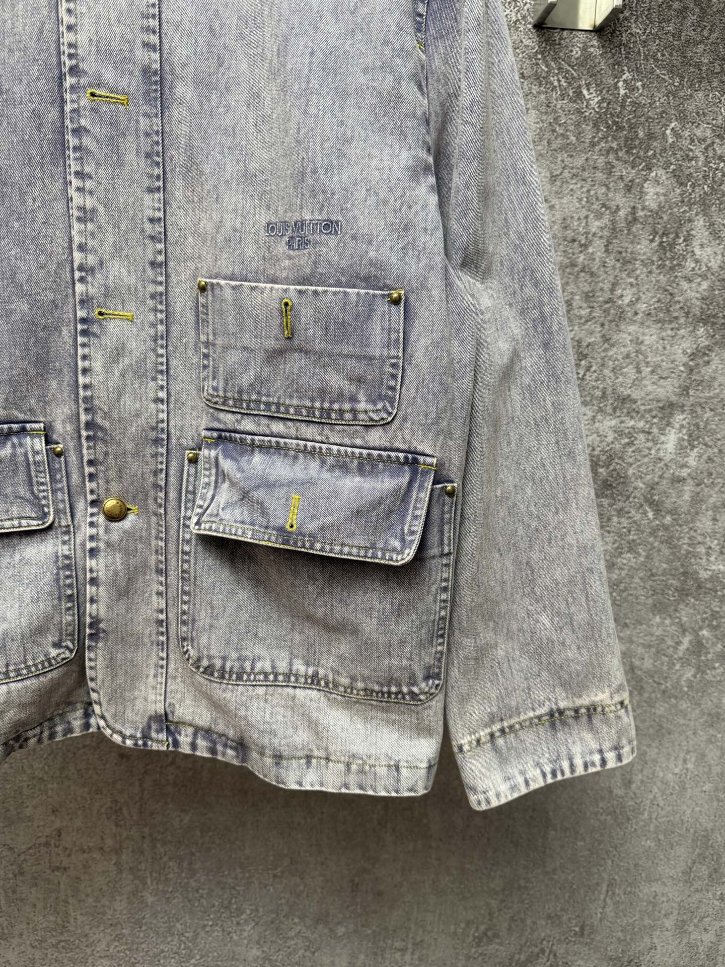 Light blue denim jacket side view with chest pockets and button details