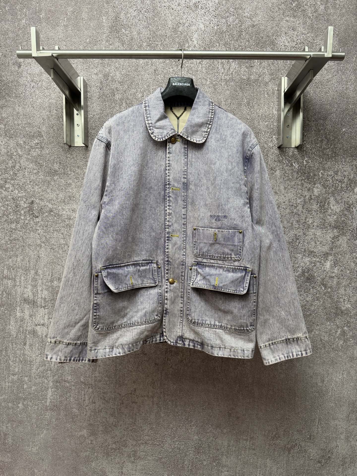 Light blue denim jacket with button front, point collar, and two chest flap pockets