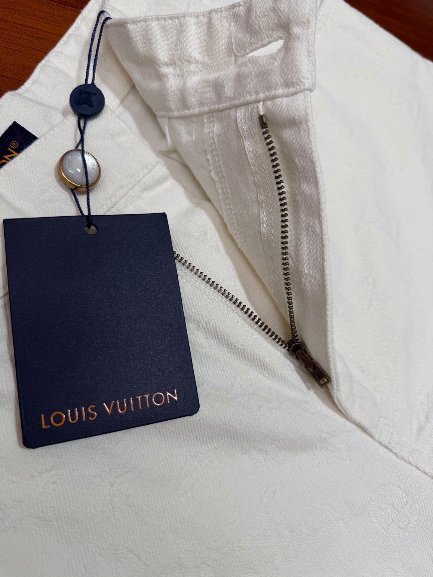 White shorts with Louis Vuitton hang tag and fabric zipper trim