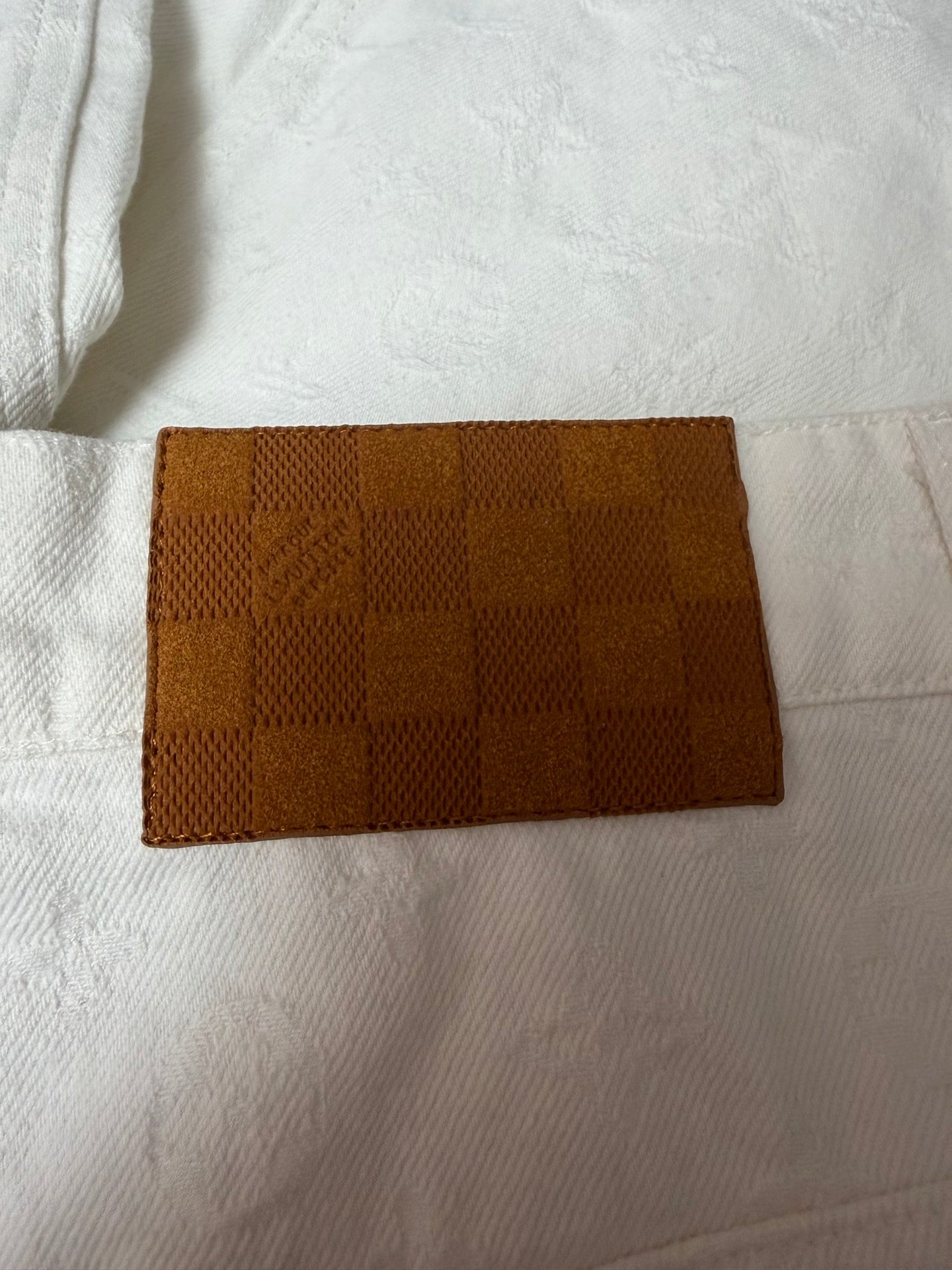 White shorts fabric with brown woven patch detail