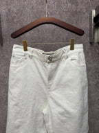 White shorts with elastic waistband, front button, and side pockets