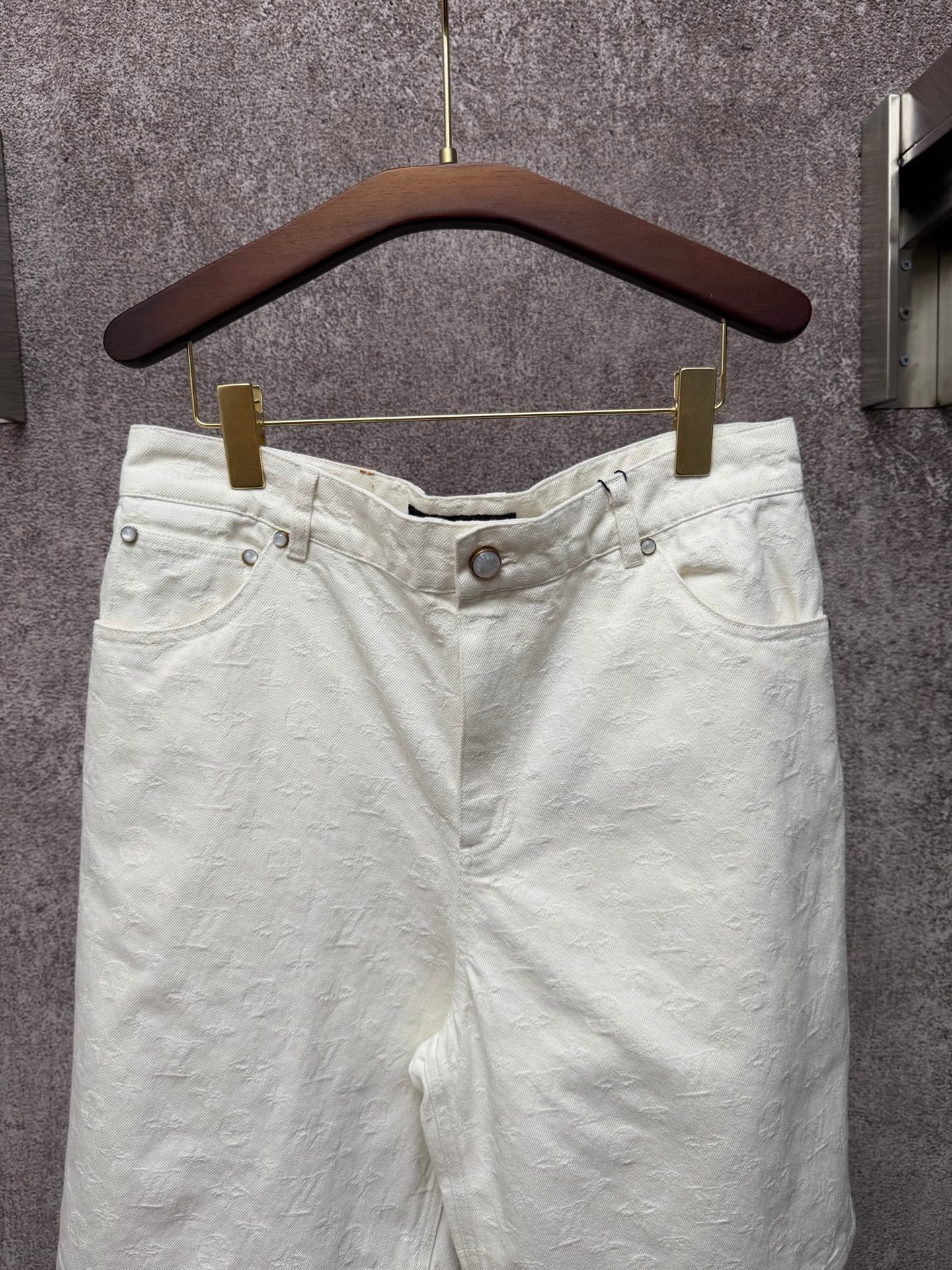 White shorts with elastic waistband, front button, and side pockets