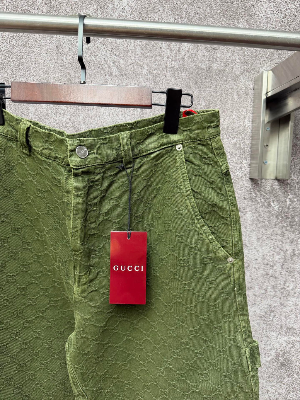 Green Gucci shorts waistband detail with button and tag