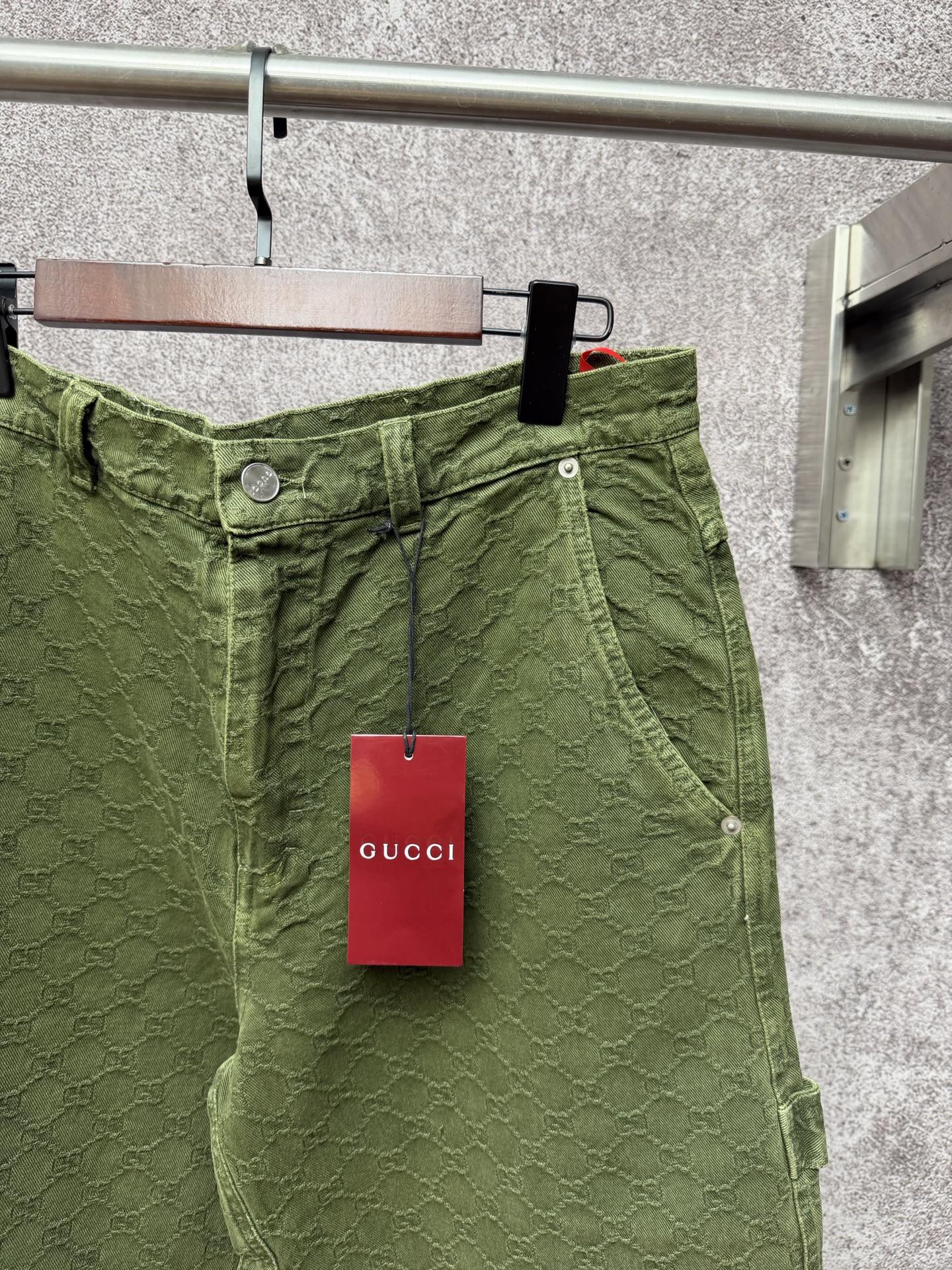 Green Gucci shorts waistband detail with button and tag