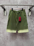 Green Gucci shorts with monogram pattern, button fly and belt loops