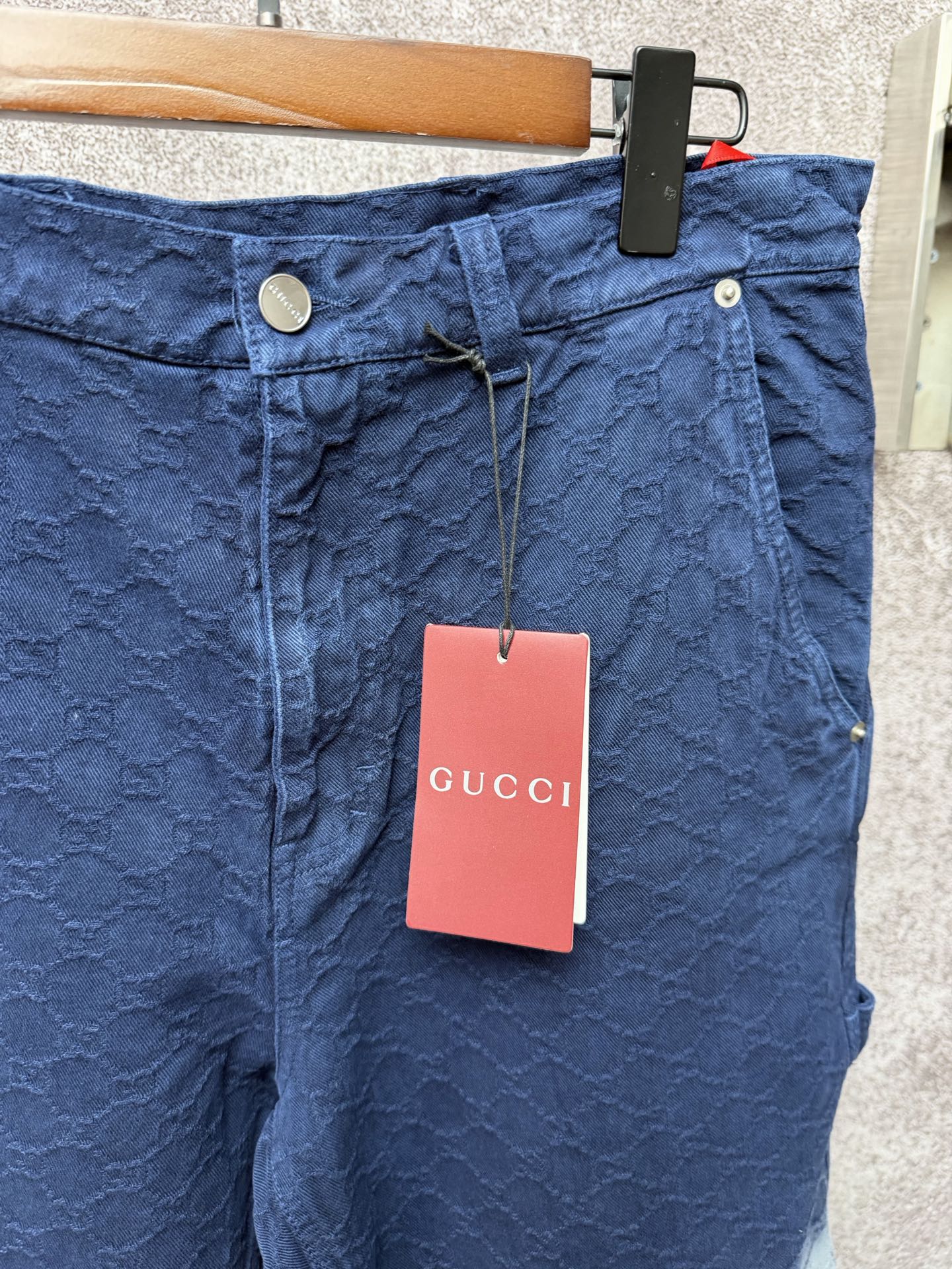 Gucci navy shorts with button fly and quilted texture, brand tag hanging