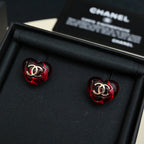 Red Chanel stud earrings with gold CC emblem on glossy round discs