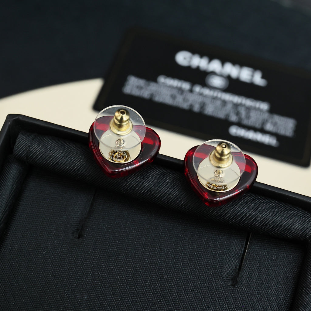 Red and gold Chanel stud earrings with circular faceted design and CC emblem