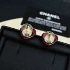 Red and gold Chanel stud earrings with circular faceted design and CC emblem