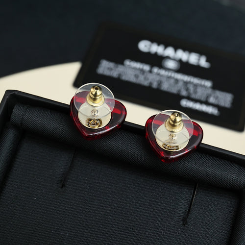 Red and gold Chanel stud earrings with circular faceted design and CC emblem