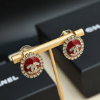 Gold-tone logo earrings with red enamel centers and rhinestone frame