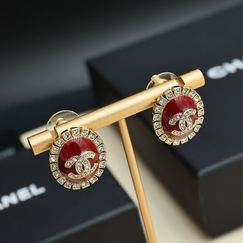 Gold-tone logo earrings with red enamel centers and rhinestone frame