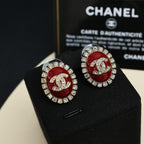 Silver-tone round logo stud earrings with red enamel and clear crystals