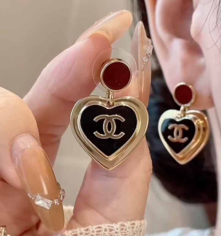 Heart dangle earrings with red enamel tops and black CC heart charms on gold posts