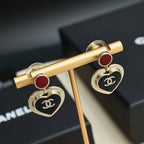 Gold-tone heart dangle earrings with red enamel discs and black CC heart medallions
