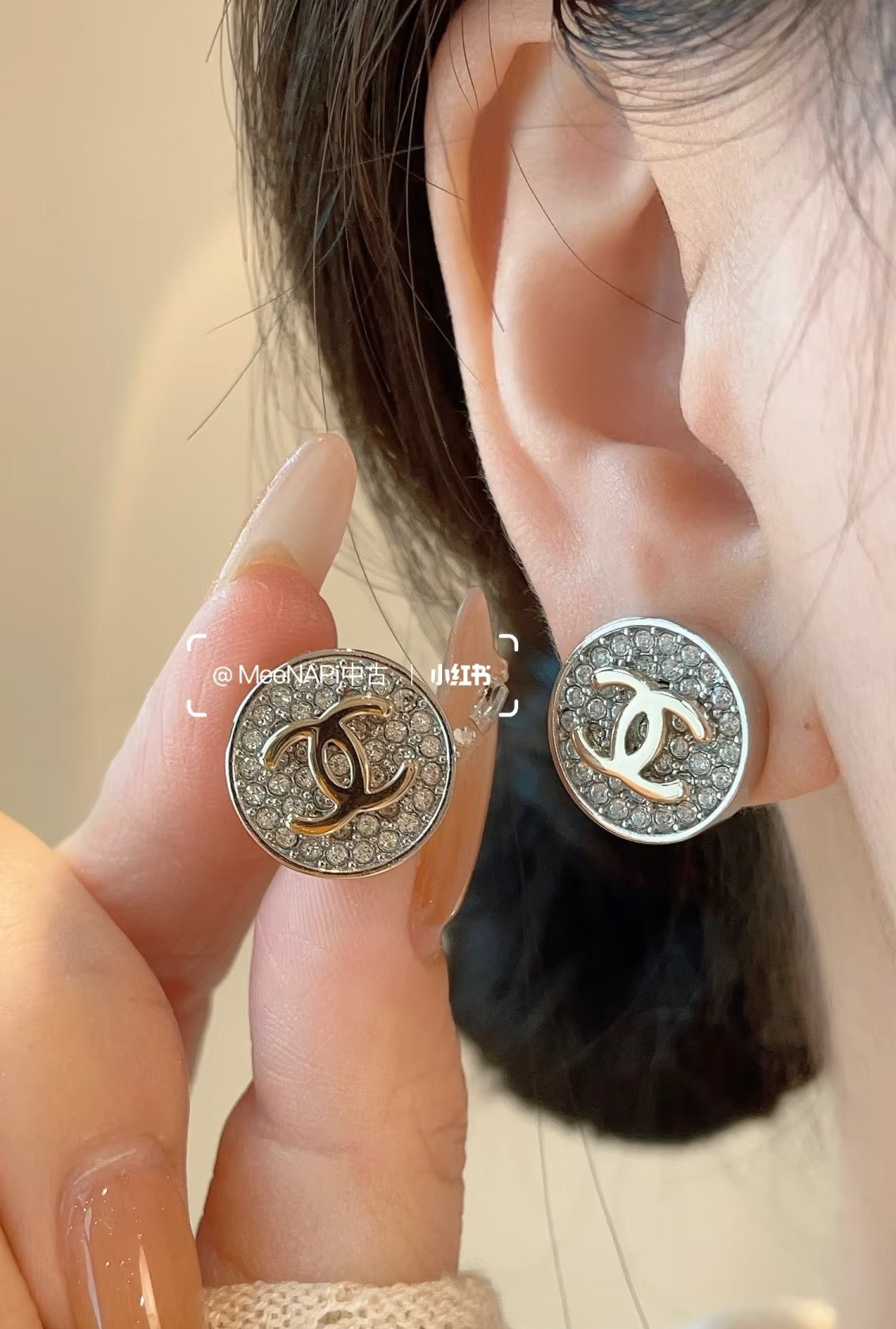 CC stud earrings on ear, round silver-tone pavé with gold CC center