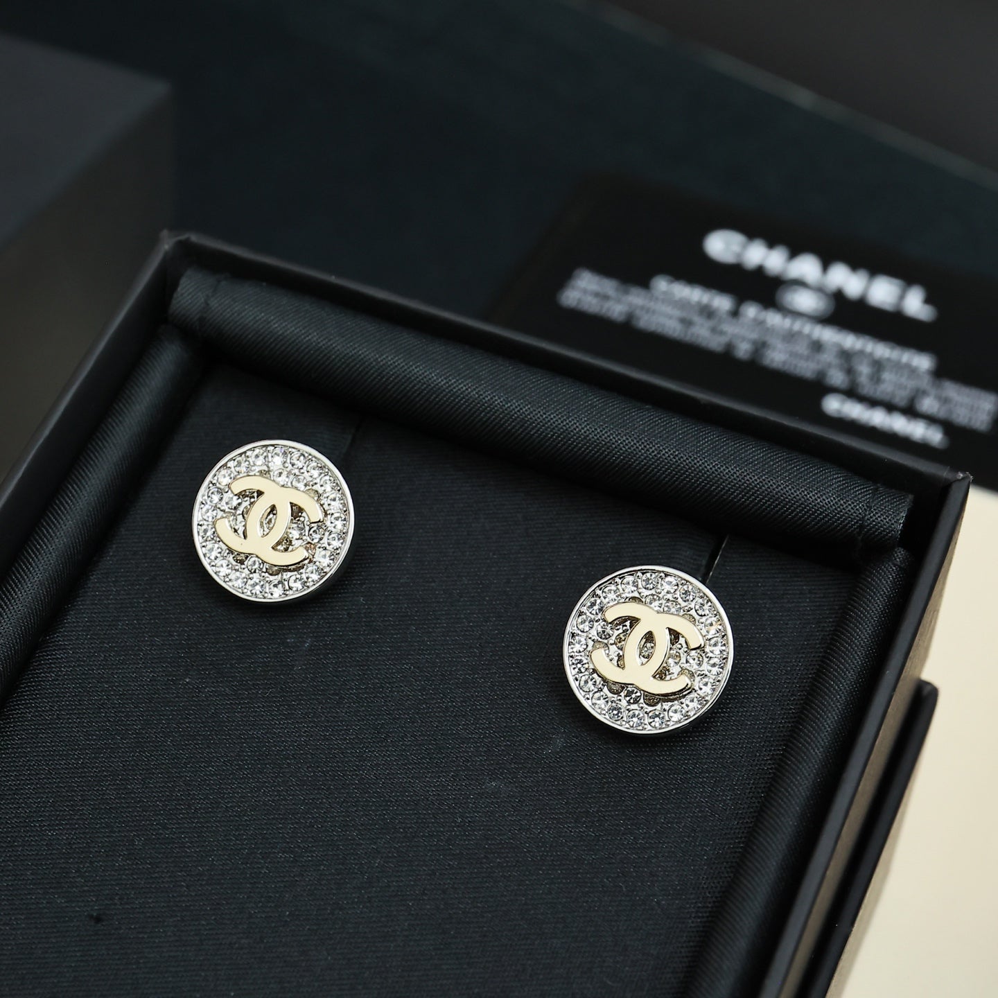CC stud earrings, round silver-tone with pavé border and gold CC center, in box