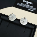 Round silver-tone stud earrings with textured face and screw posts