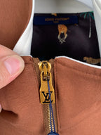 Brown jacket zipper close-up with Louis Vuitton V emblem and gold hardware pull