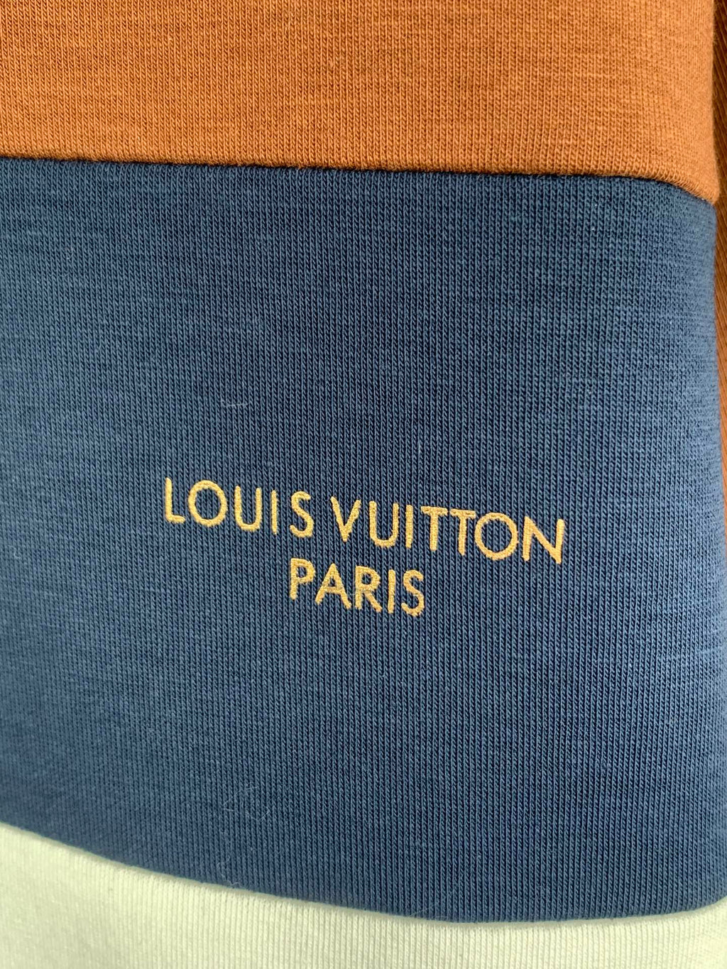 Blue fabric stripe with yellow text reading LOUIS VUITTON PARIS