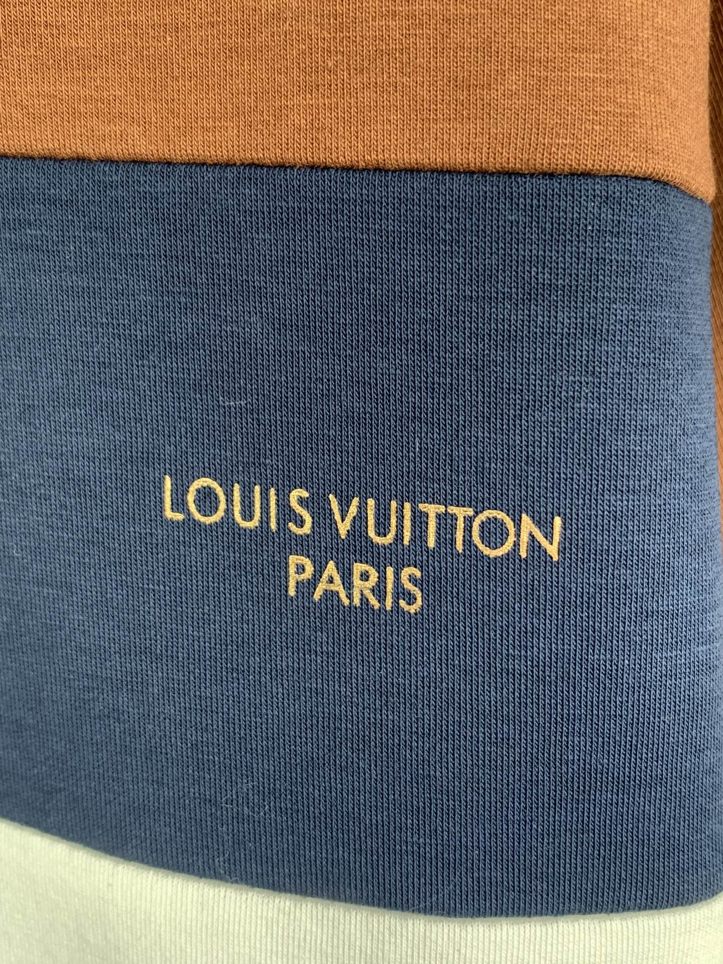 Blue fabric stripe with yellow text reading LOUIS VUITTON PARIS