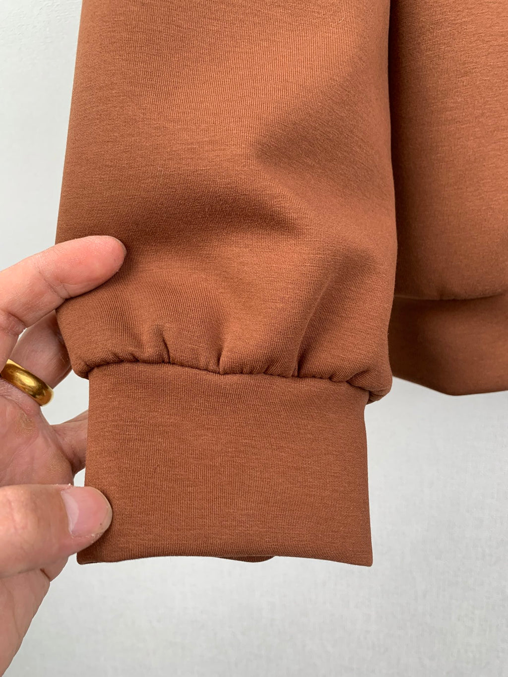 Brown jacket sleeve cuff with gathered seam detail and elastic hem