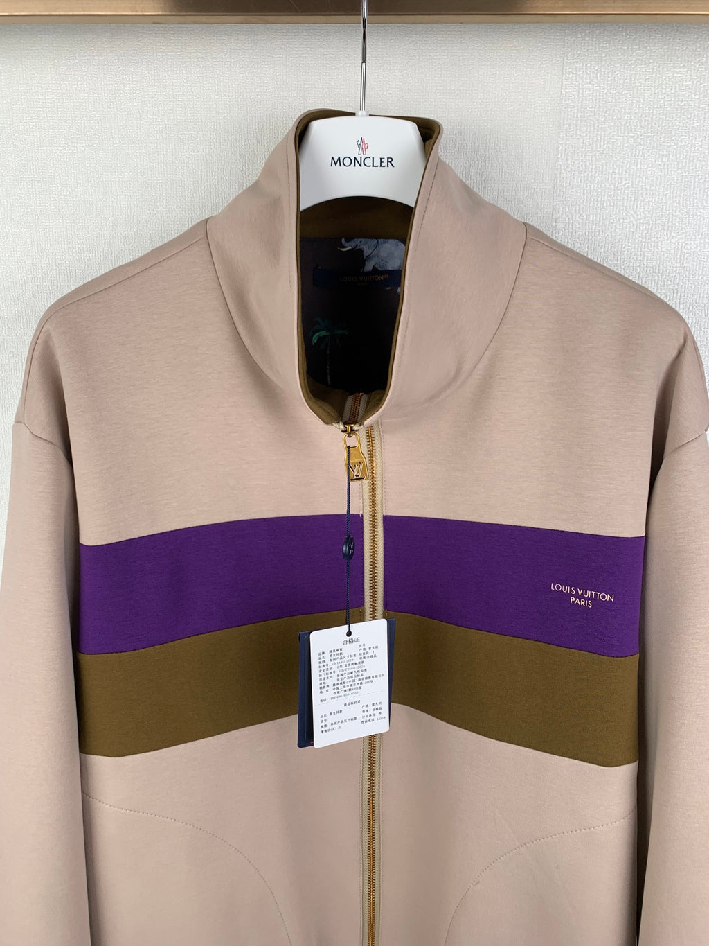 Beige zip-up jacket with purple and olive stripe, gold zipper, stand collar