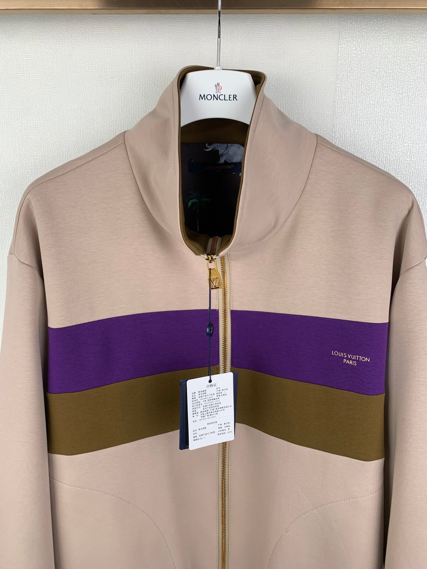 Beige zip-up jacket with purple and olive stripe, gold zipper, stand collar