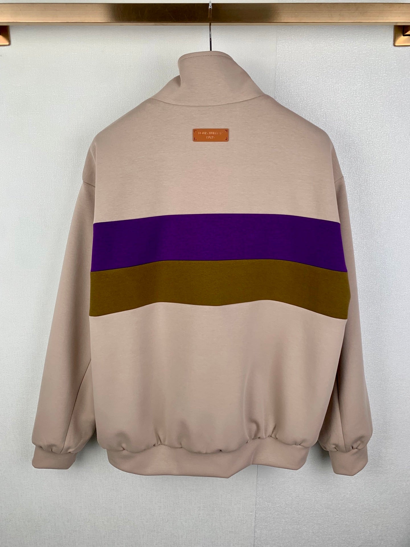 Beige zip-up jacket back view with purple and olive horizontal stripe