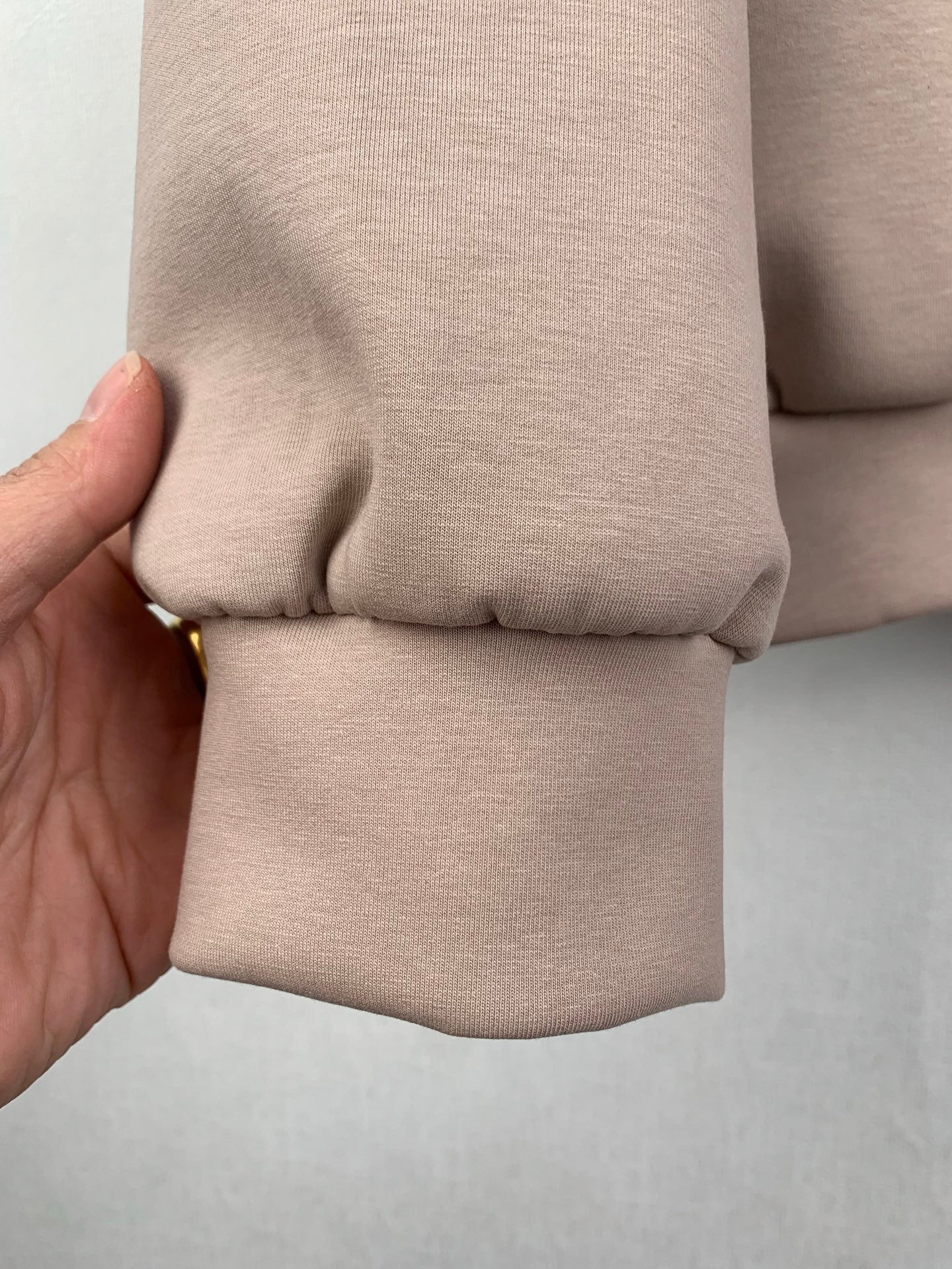 Beige jacket sleeve cuff with elastic hem and stitched seam