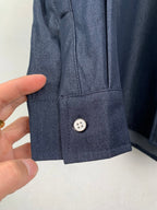 Dark blue shirt cuff close-up with single button detail